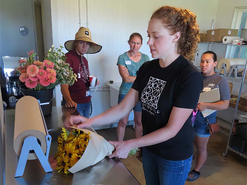 Farmer Jenna Cook demonstrates her bouquet wrapping technique at her farm, Clovergold Flowers, in western Iowa.